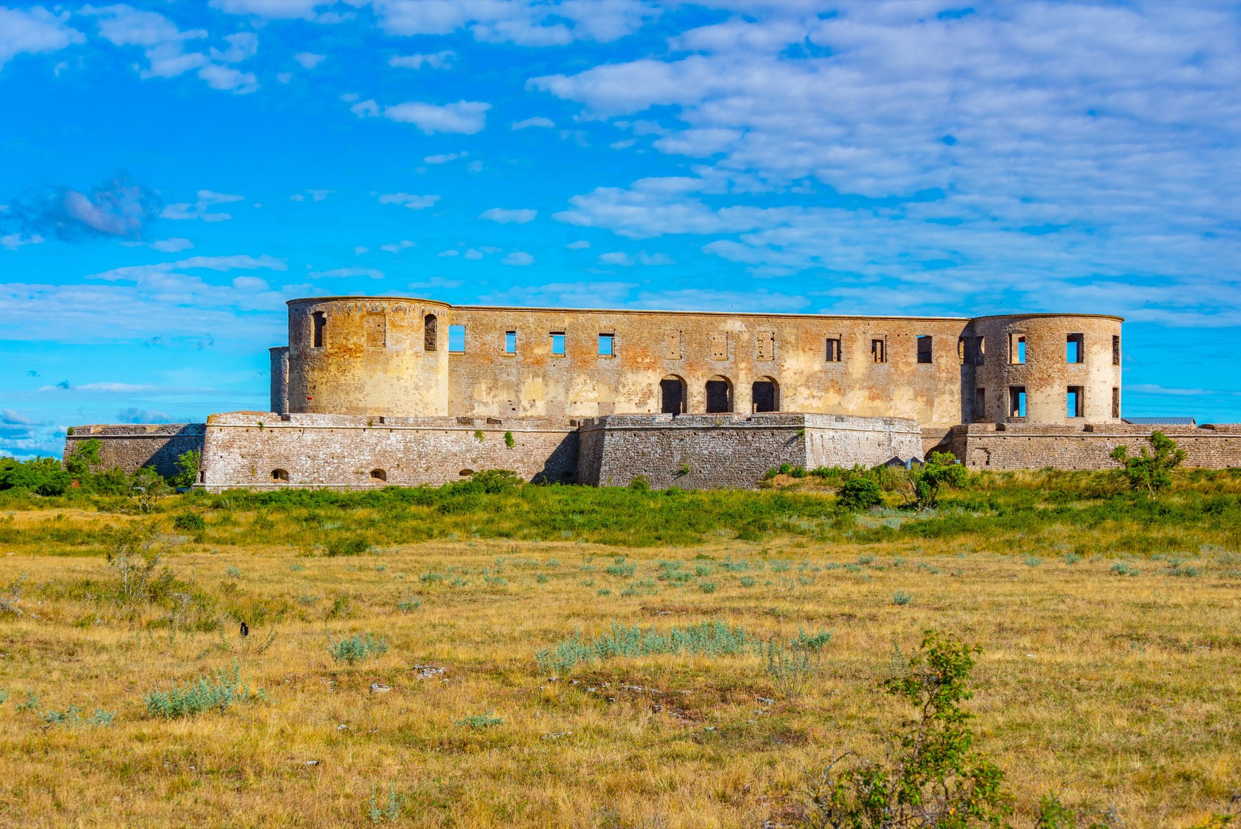 Borgholm Slott im sonnigen Licht: massive Steinmauern und Rundtürme der mittelalterlichen Burgruine.