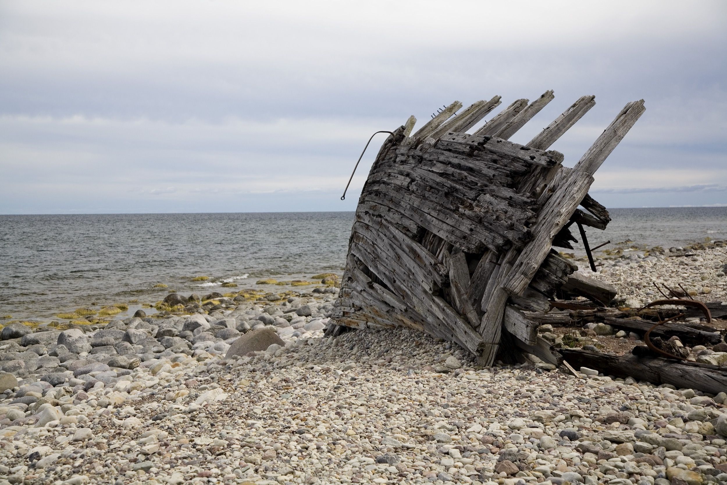 Verlassenes Schiffswrack am Kiesstrand des Waldgebiets Trollskogen auf Öland.