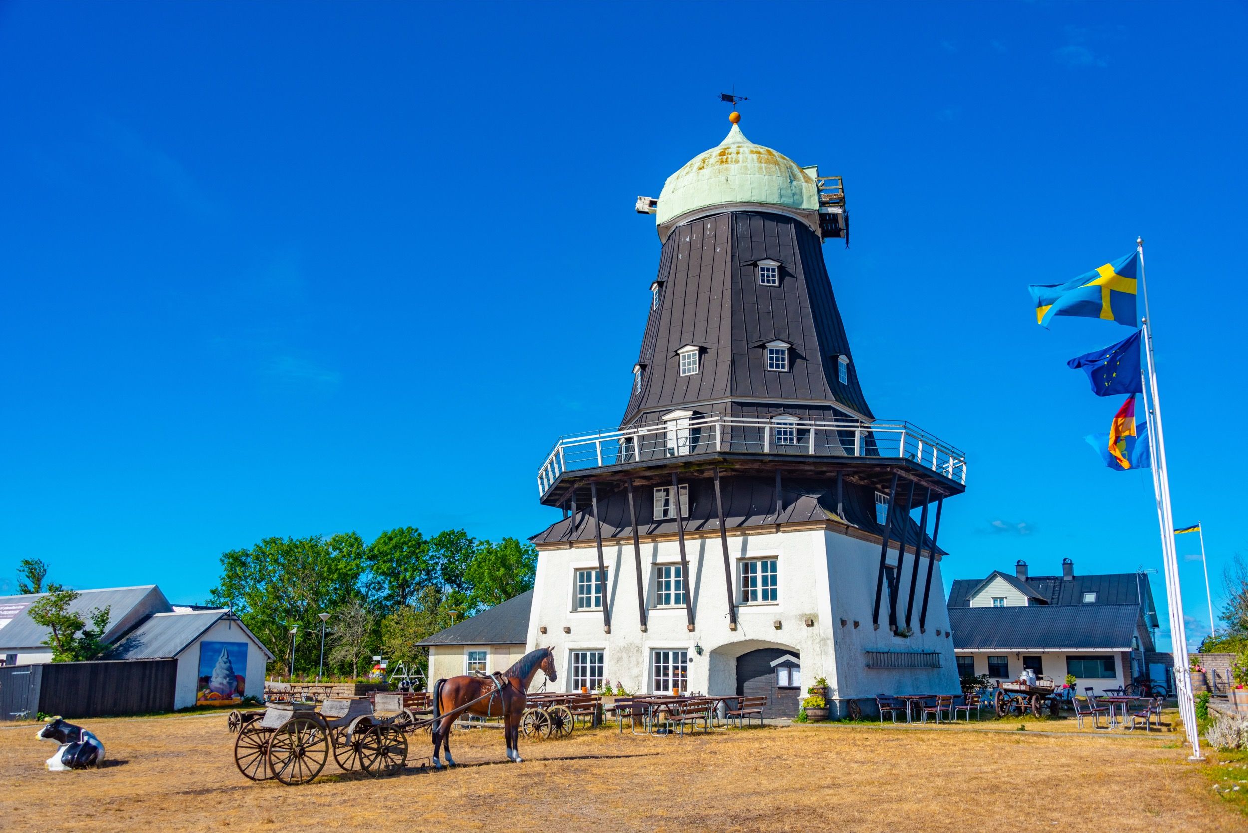 Sandvik-Mühle: holländische Poldermühle mit grünem Dach und Pferdekarren im Vordergund.