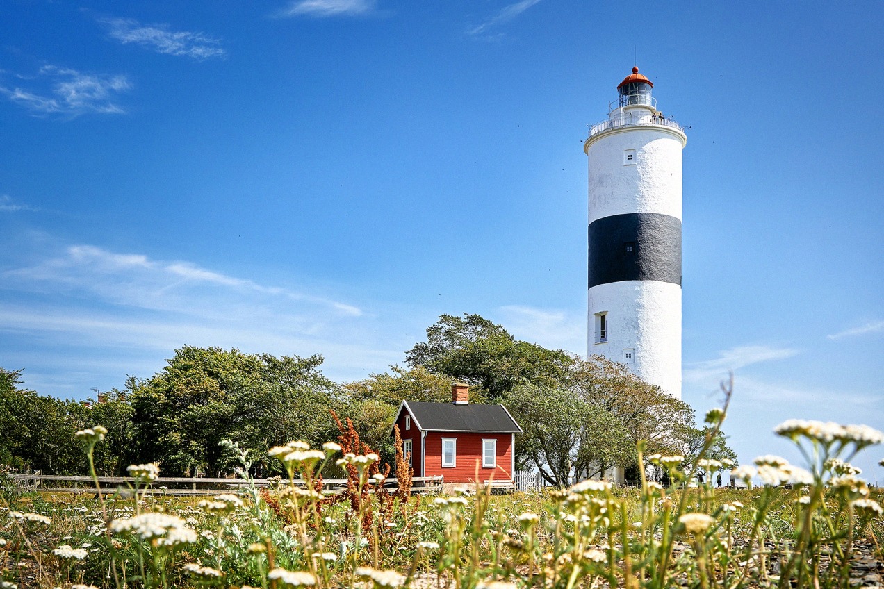 Der Leuchtturm Långe Jan mit schwarz-weißem Anstrich und rotem Wärterhäuschen an Ölands Südspitze.